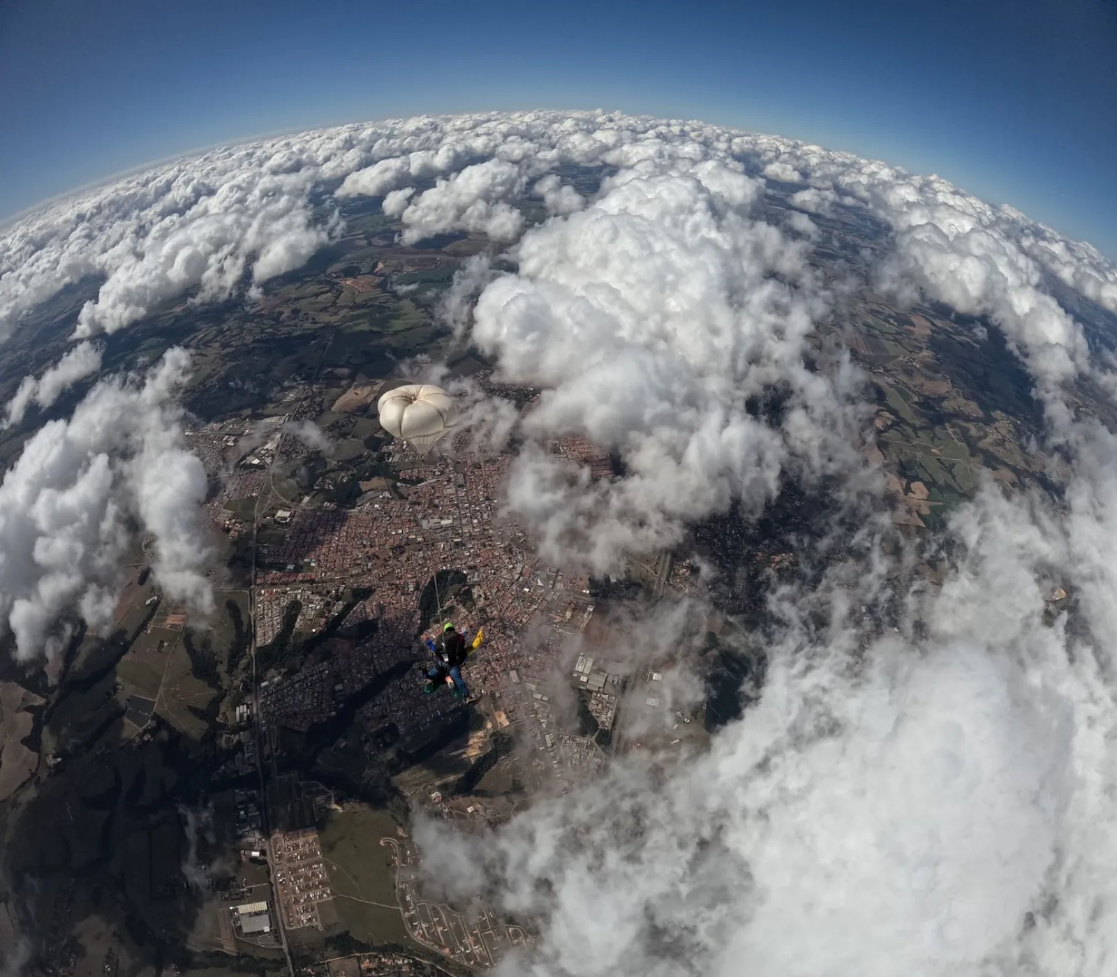 A skydiver descending through open sky and clouds